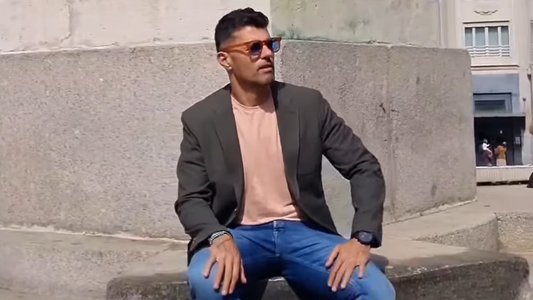 Hombre con americana gris y camiseta rosa mostrando ropa de entretiempo para hombres 